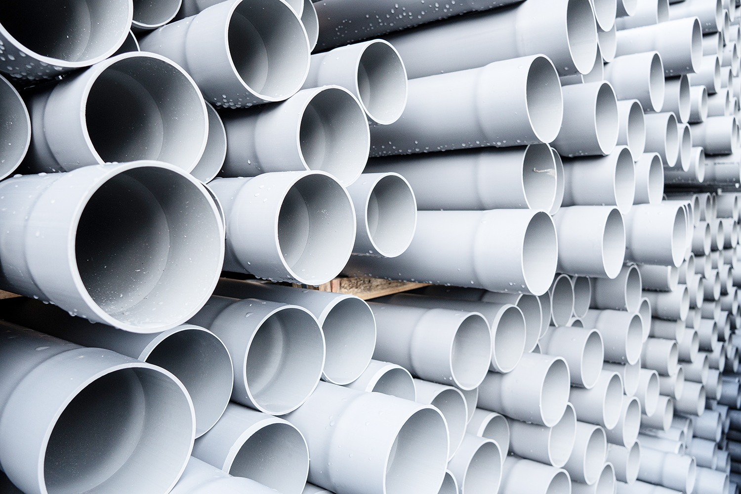Gray PVC tubes plastic pipes stacked in rows